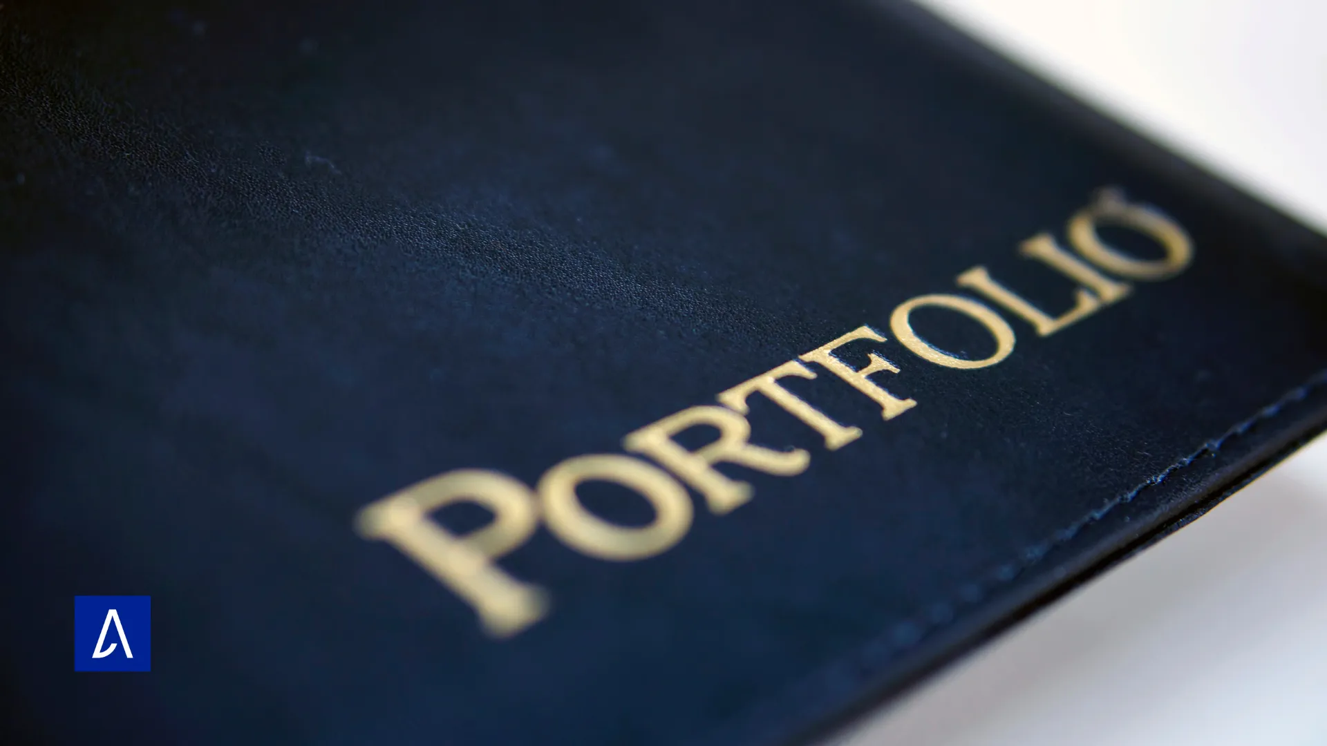 Gros plan sur une couverture noire avec le mot « Portfolio » écrit en lettres dorées.