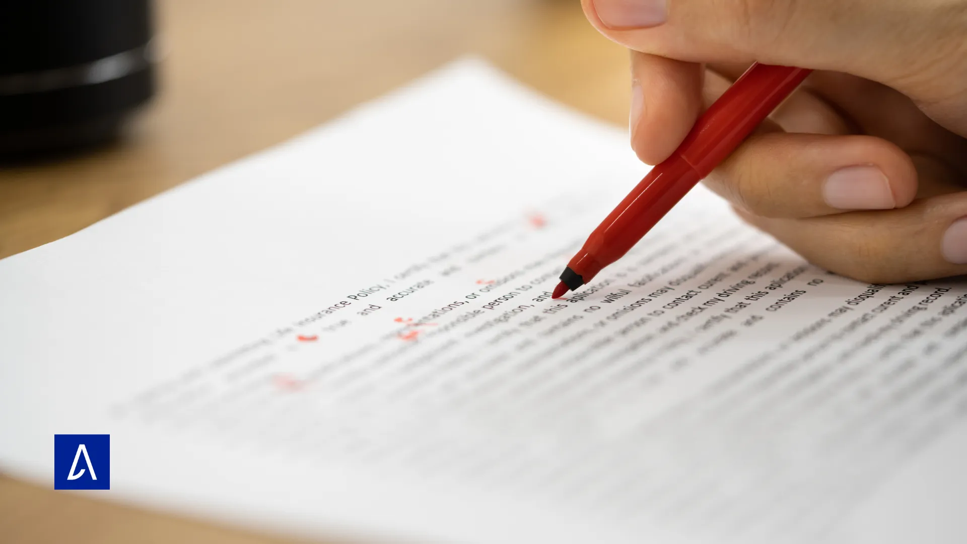 Correction d’un texte imprimé avec un stylo rouge, illustrant le travail de relecture en copywriting.