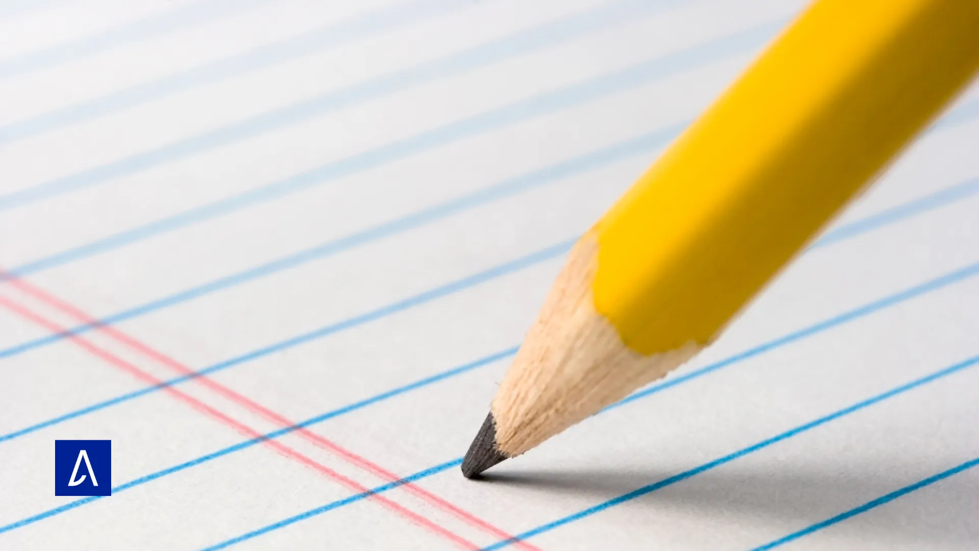 Crayon jaune taillant une ligne sur une feuille à grands carreaux, représentant l’écriture, la précision et la concentration.