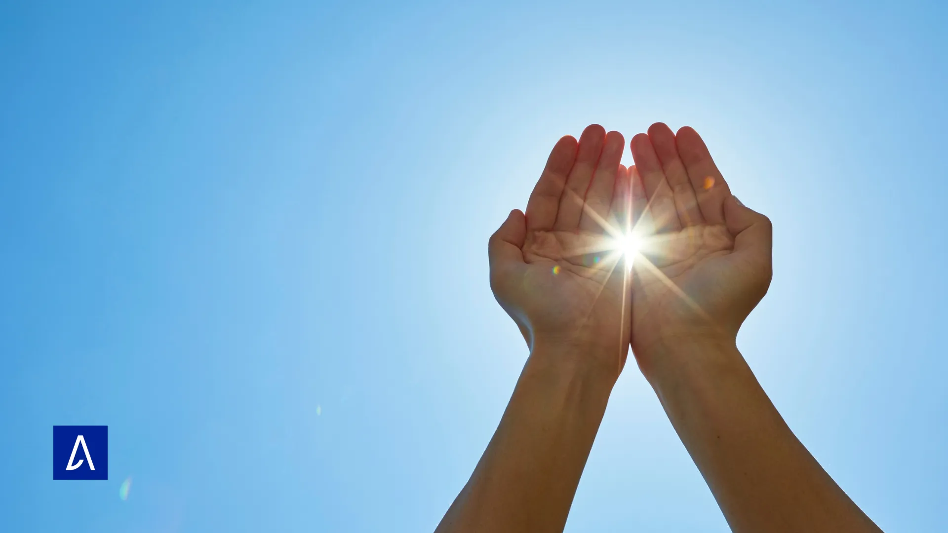 Mains ouvertes capturant la lumière du soleil sur fond de ciel bleu, symbolisant l’inspiration et la clarté d’esprit.
