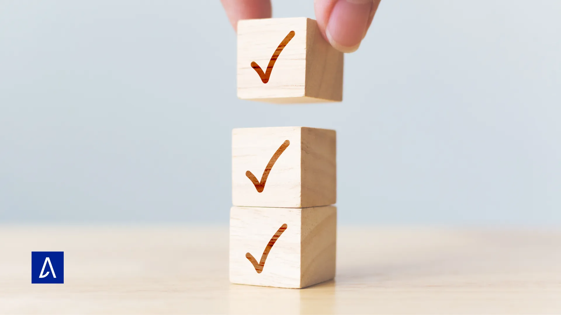 Blocs de bois empilés avec des coches symbolisant des tâches validées.