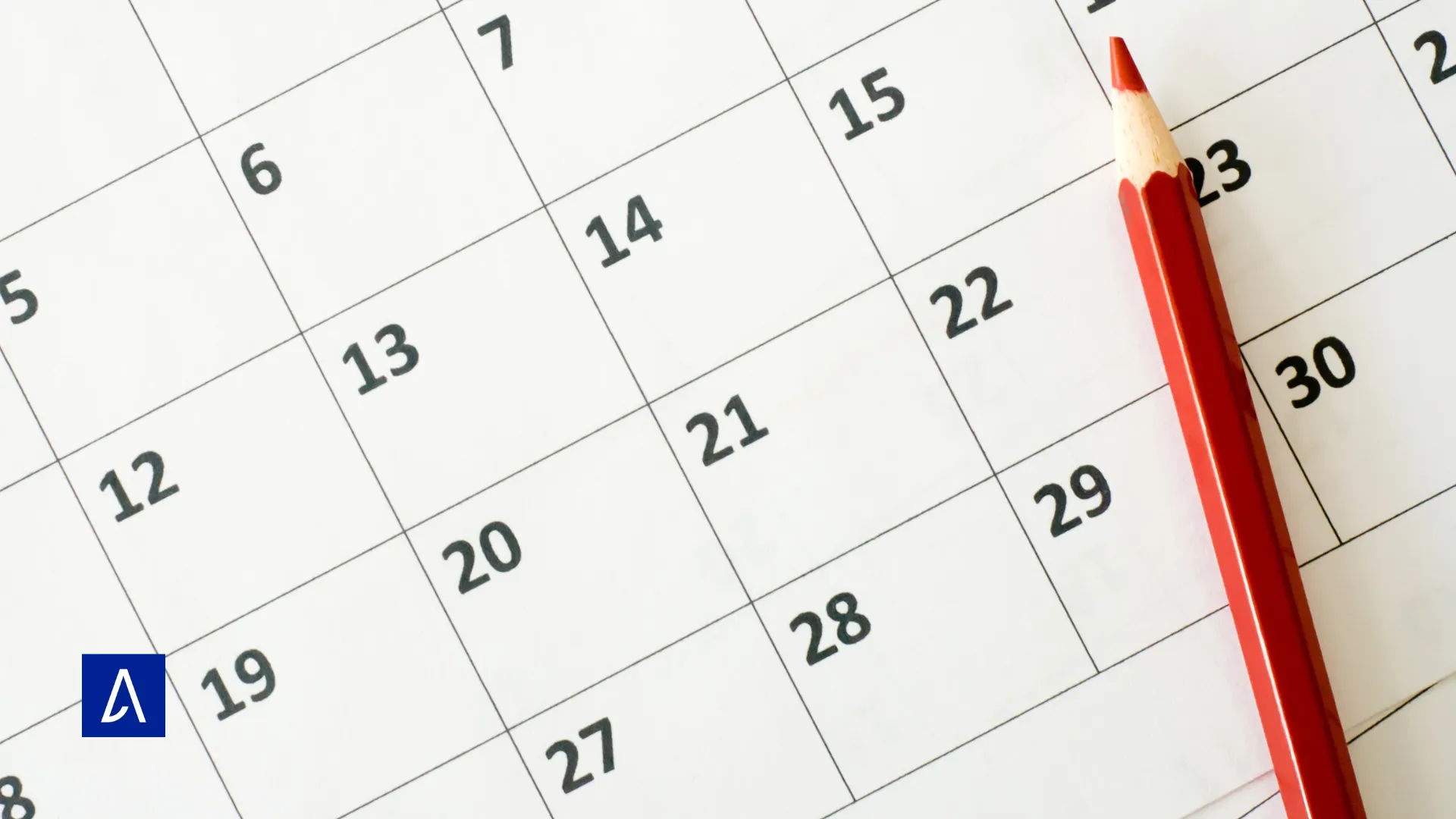 Calendrier mensuel avec un crayon rouge posé sur une date.