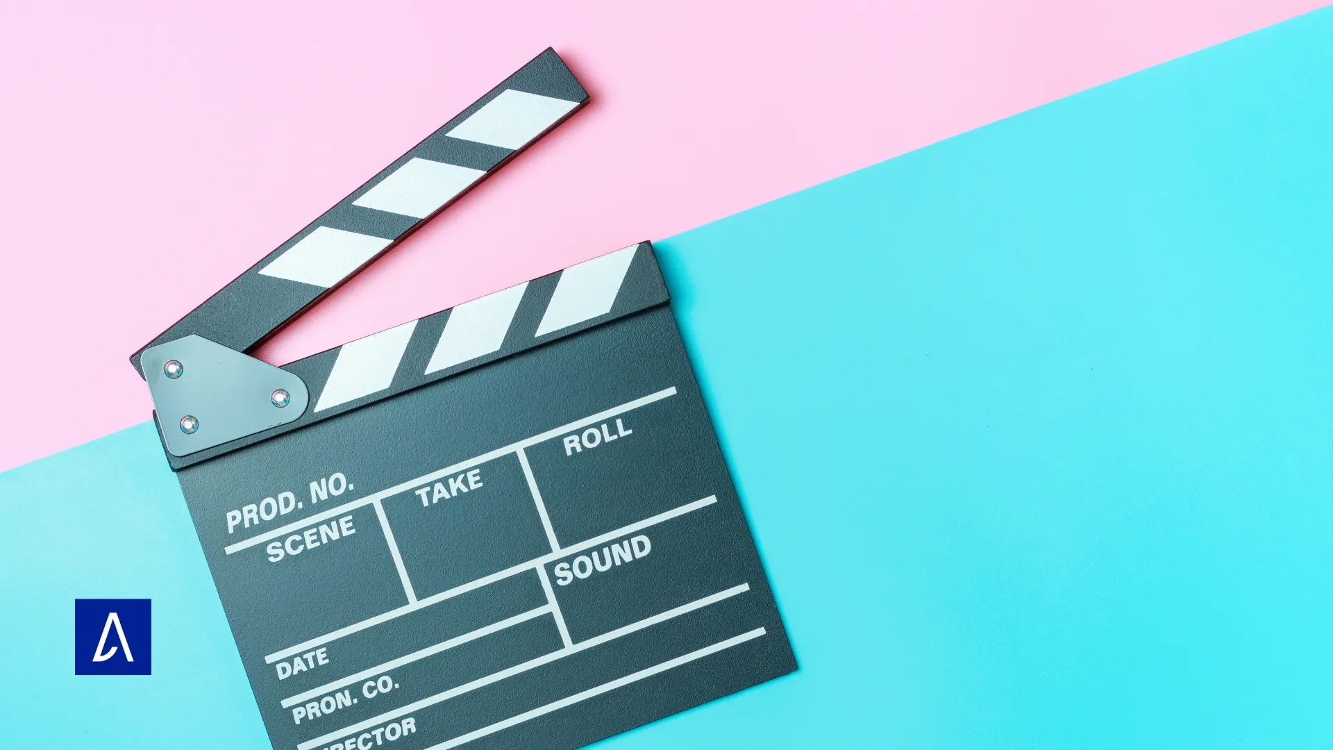 Clap de cinéma posé sur un fond coloré rose et bleu.