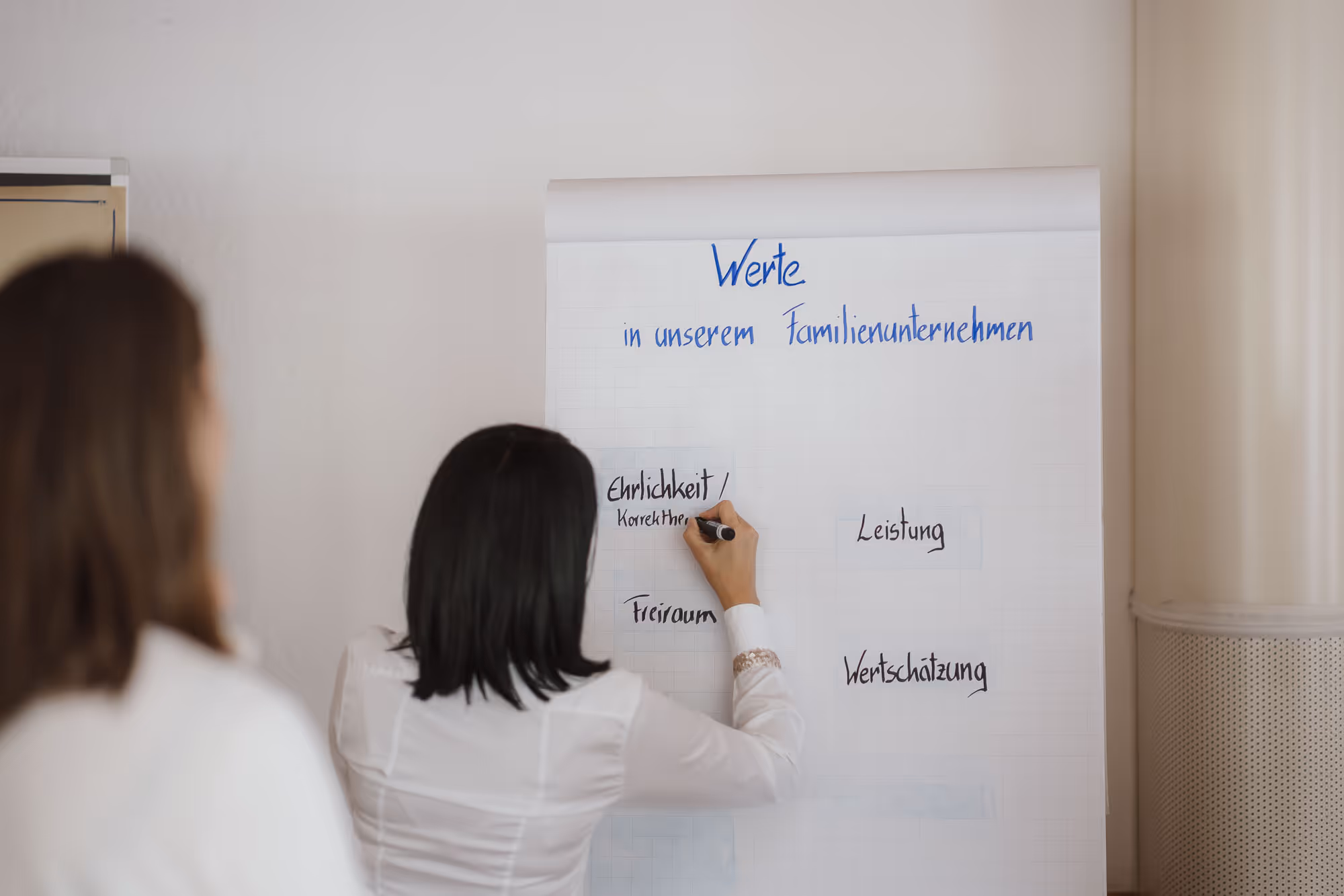 Andrea schreibt Werte auf einen Flipchart