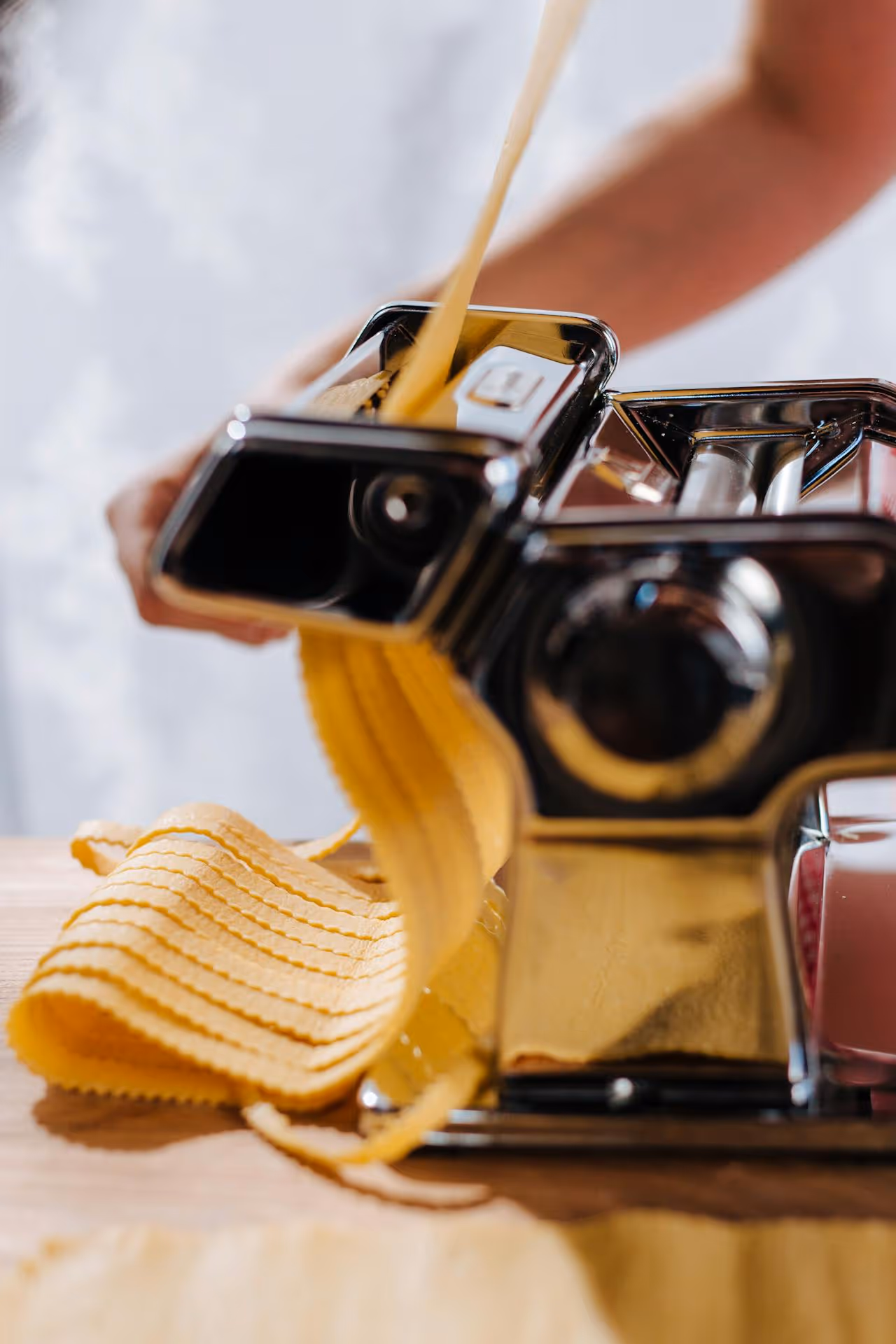 Image of a machine and someone making fresh pasta.