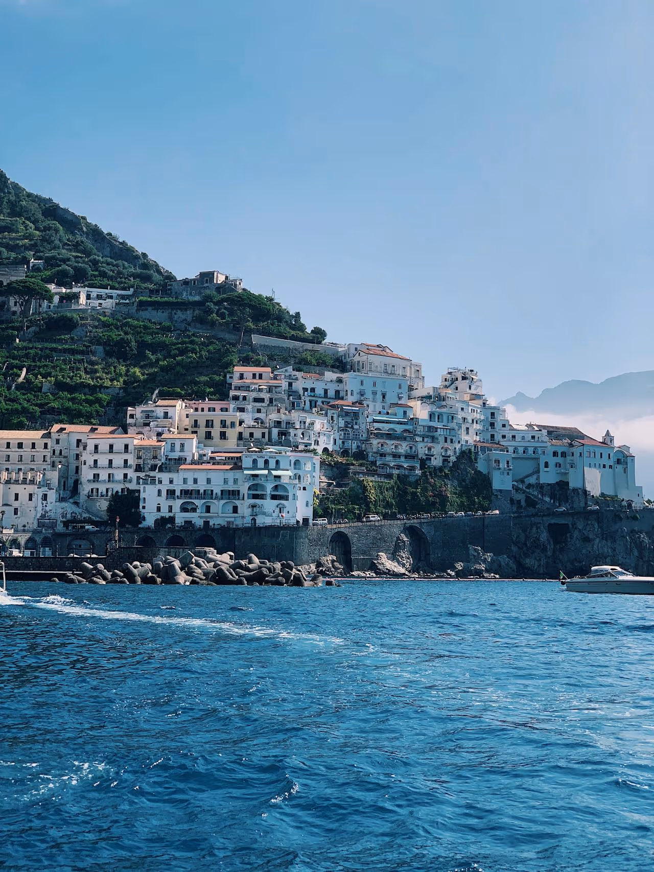 Image with a landscape of the sea and some houses.
