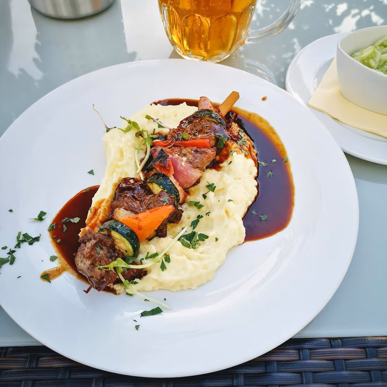 A dish with meat and smashed potato.