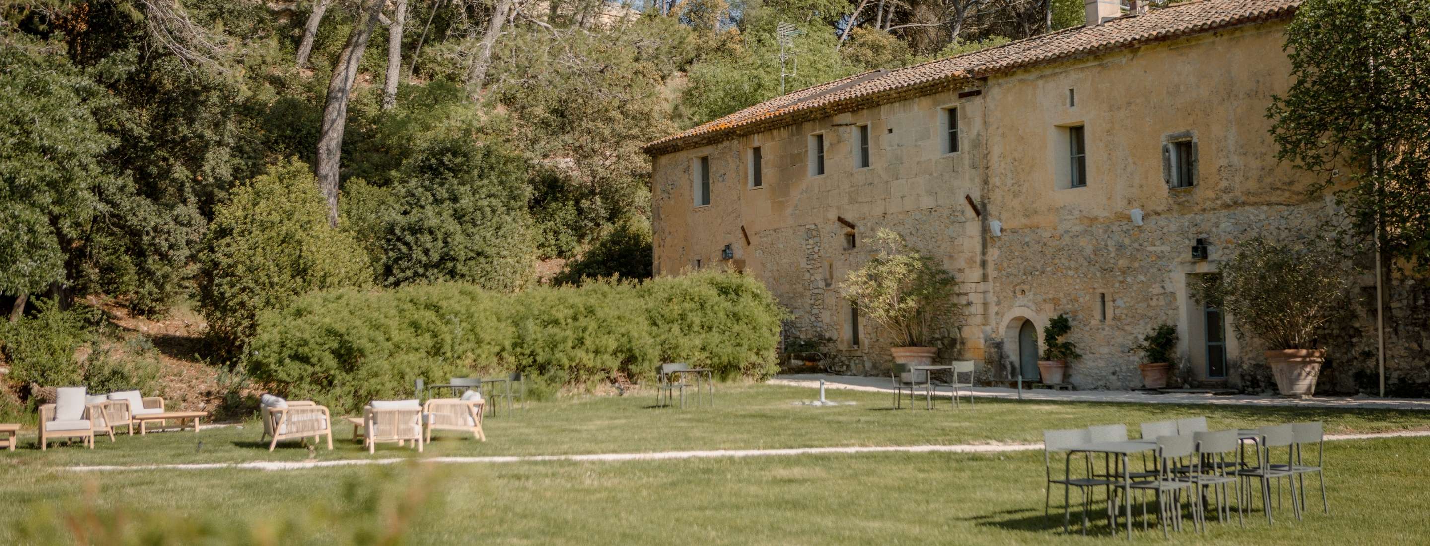 Facade of the Mas des Prêcheurs with furnished garden and furniture, in Provence, a charming building in a peaceful environment.