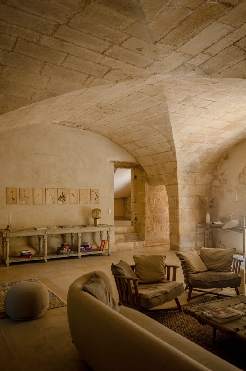 Sofas under a stone arch at the Mas des Prêcheurs hotel, in Tarascon in Provence, a warm living room with authentic charm.