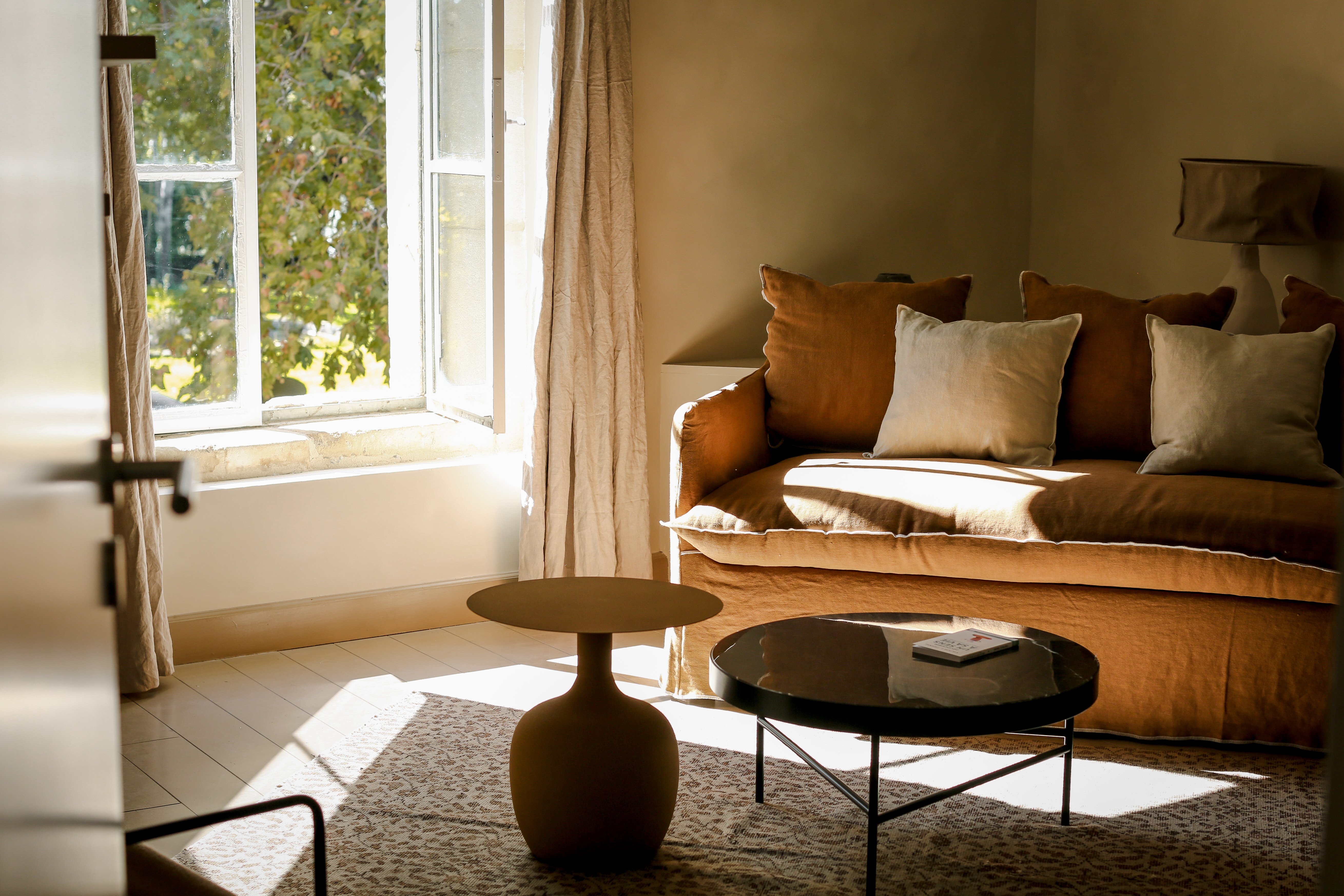 Sofa in the room of the hotel Mas des Prêcheurs , in Tarascon in Provence, warm space and elegant decoration.