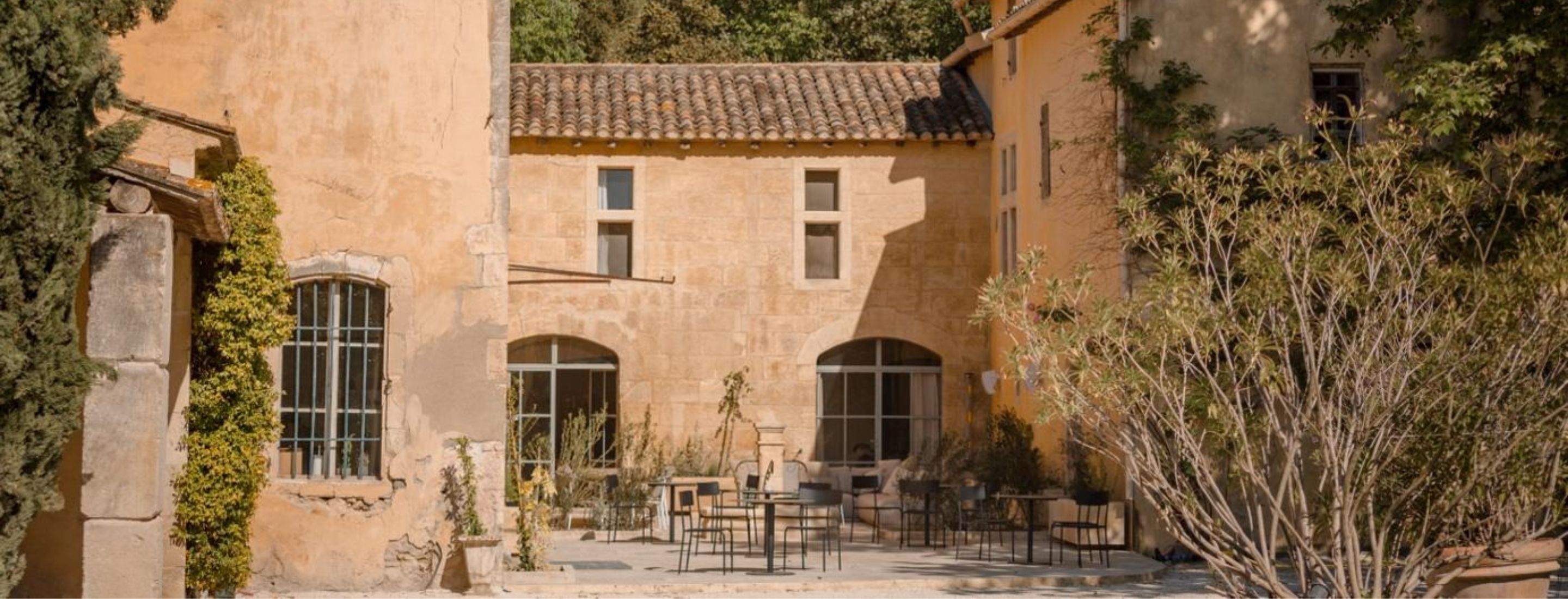 Façade du Mas des Prêcheurs avec terrasse, à Tarascon en Provence, bâtisse de caractère ouverte sur un espace extérieur aménagé.