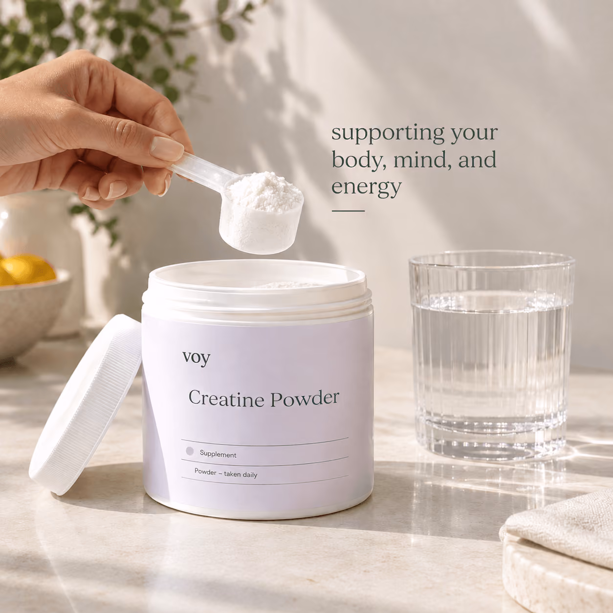 Open creatine tub on counter with scoop raised to glass