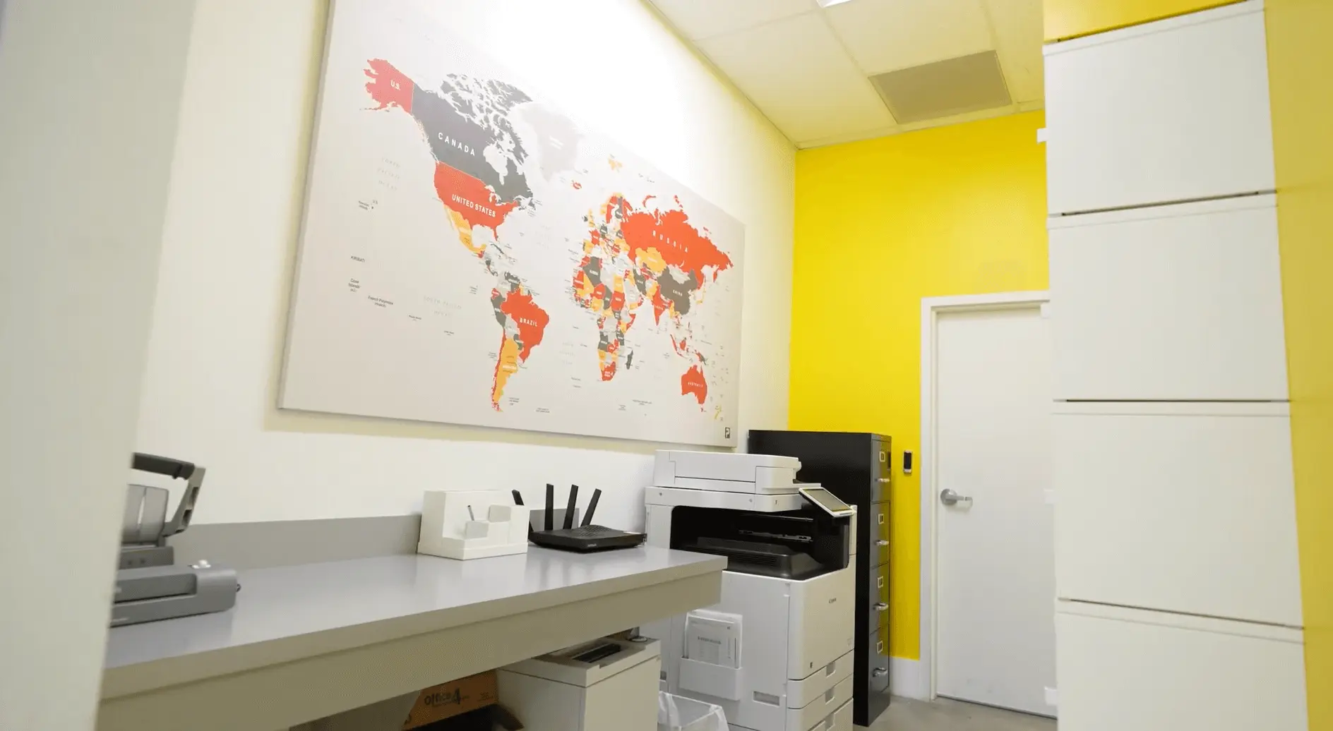 Print and copy station with world map decor at Palletized coworking offices in Miami