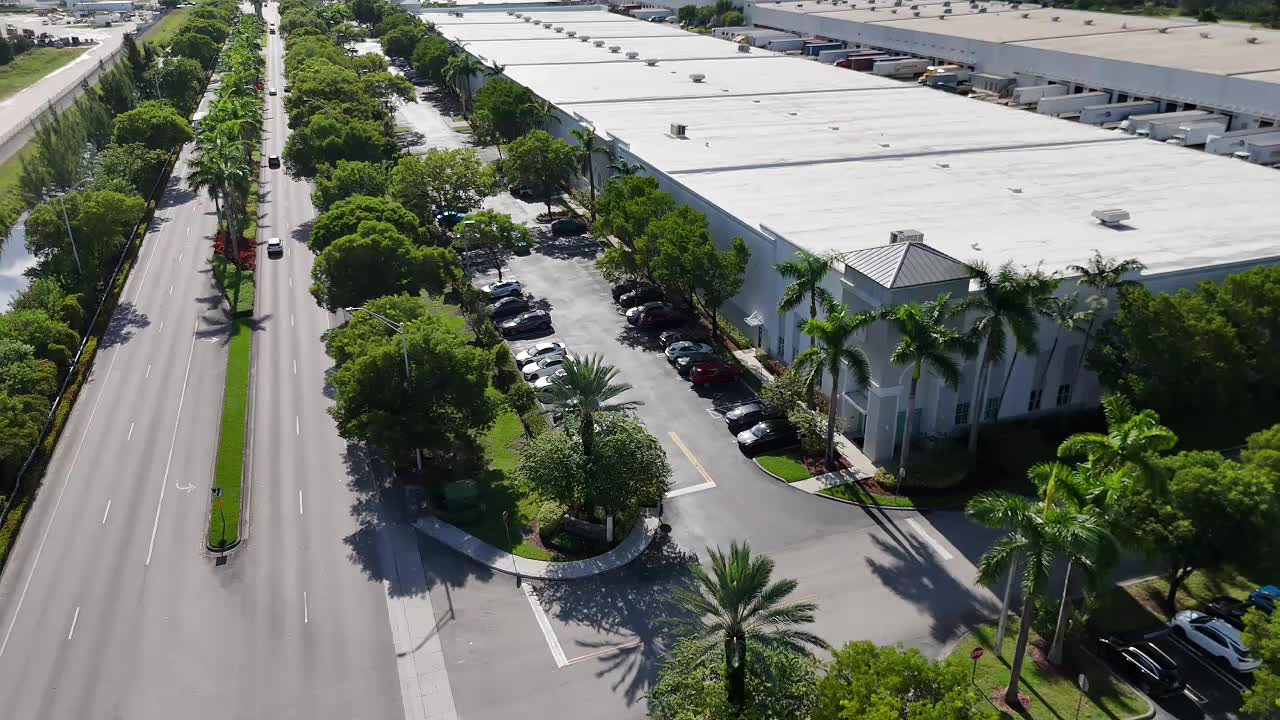 Aerial view of Palletized fulfillment center in Miami with parking lot and palm-lined street