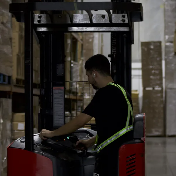 Reach truck operator moving pallets for B2B orders