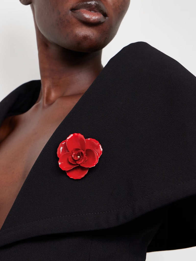woman wearing black blazer red flower brooch