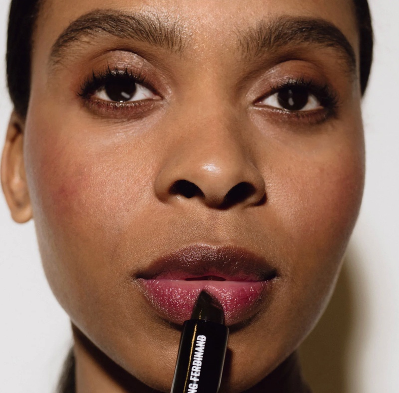 woman holding black lip balm