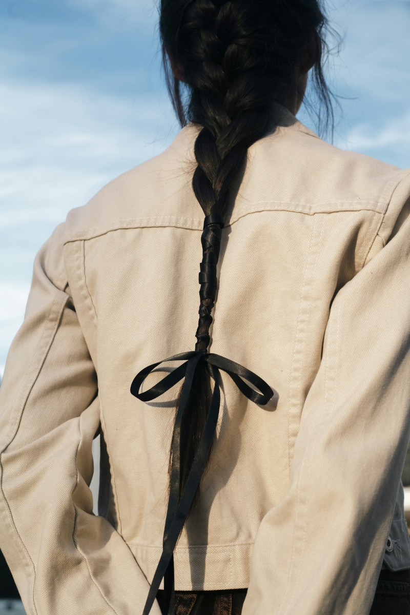 image of woman with plait hair and beige jacket