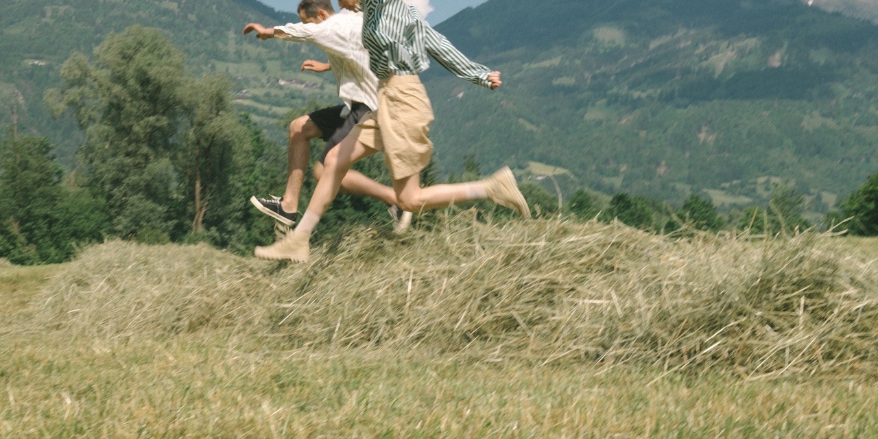man and woman running through field