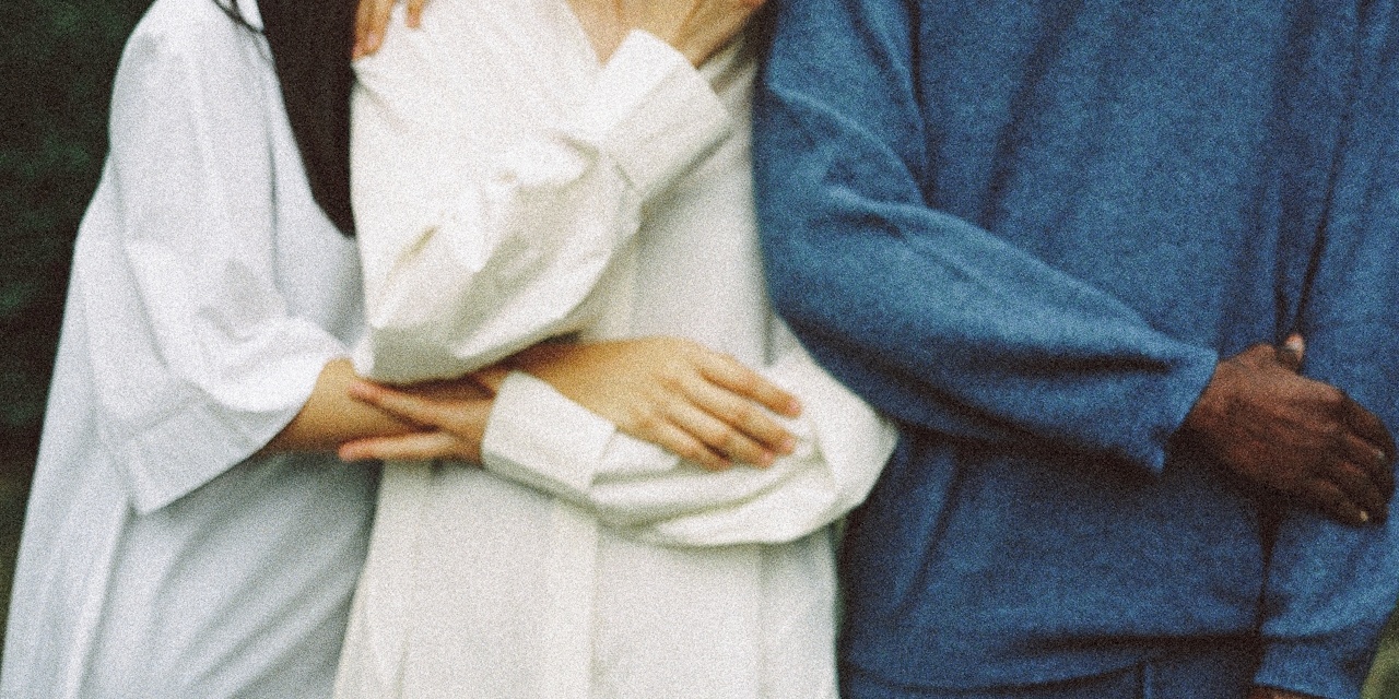 three people holding arms