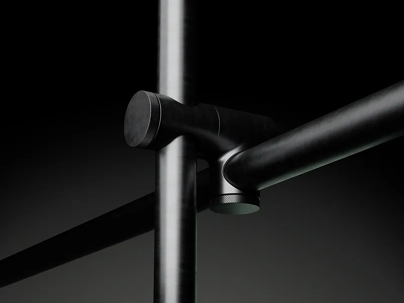 Close-up of sleek black metal joints connecting cylindrical rods with knurled adjustment knobs on a dark background.