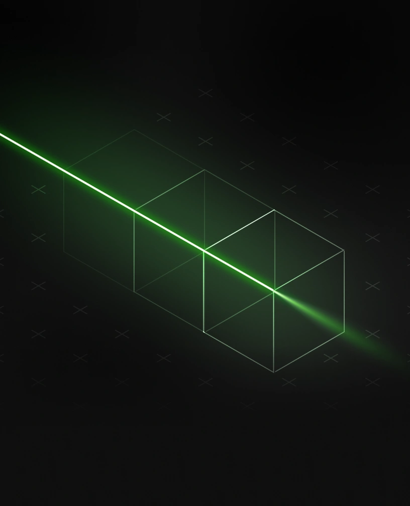Green laser beam passing through three transparent wireframe cubes on a dark background.
