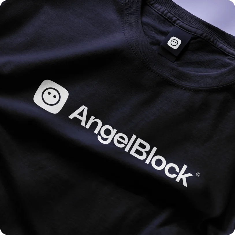 Black t-shirt with white AngelBlock logo and icon on the front and label inside the collar.