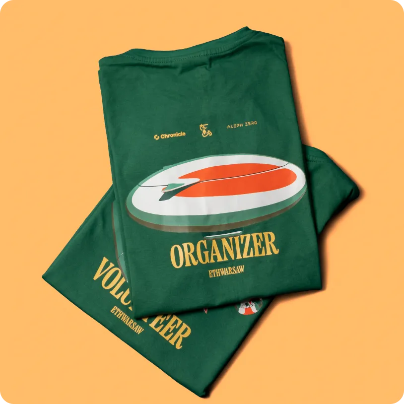 Two folded dark green t-shirts with large orange and white graphics and text labels reading 'ORGANIZER' and 'VOLUNTEER' on an orange background.