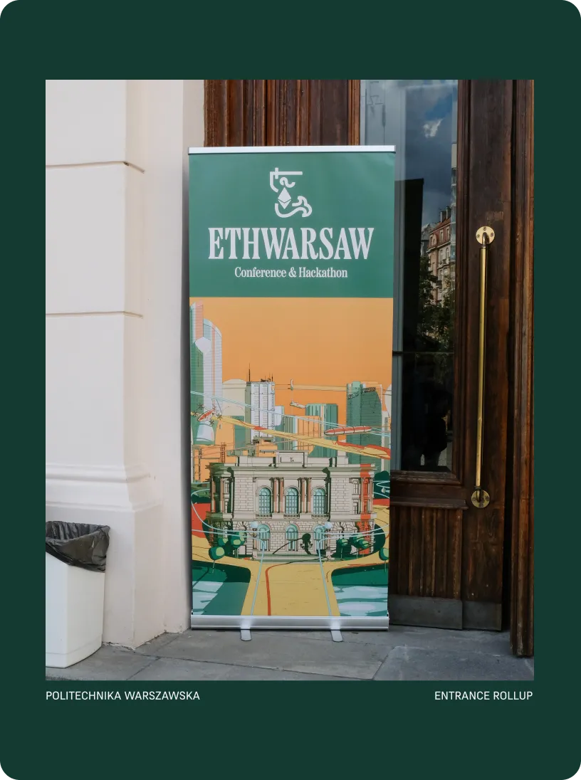 Rollup banner at entrance showing ETHWARSAW Conference & Hackathon with an illustrated cityscape and classic building.