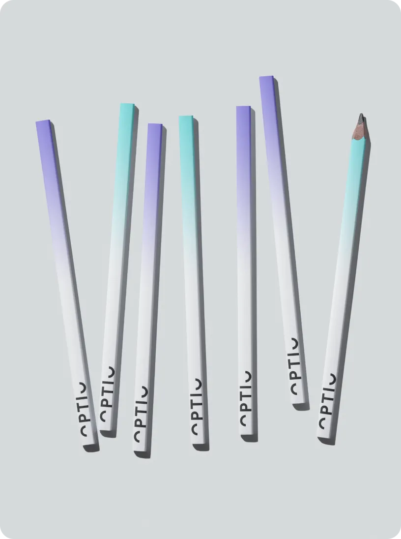 Seven gradient-colored pencils with the brand name 'OPTIO' printed near the ends, arranged diagonally on a gray background, one pencil is sharpened.