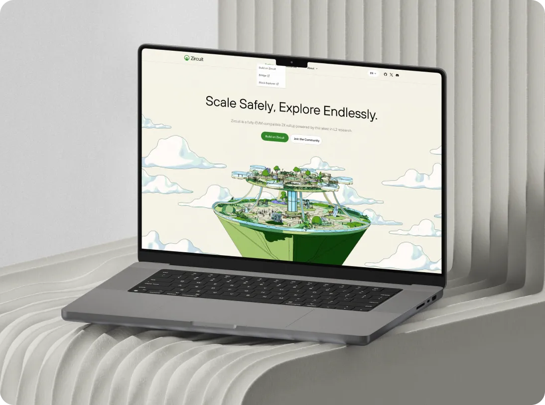 Gray laptop on a white textured surface displaying Zircuit website with the text 'Scale Safely, Explore Endlessly' and a floating island illustration.