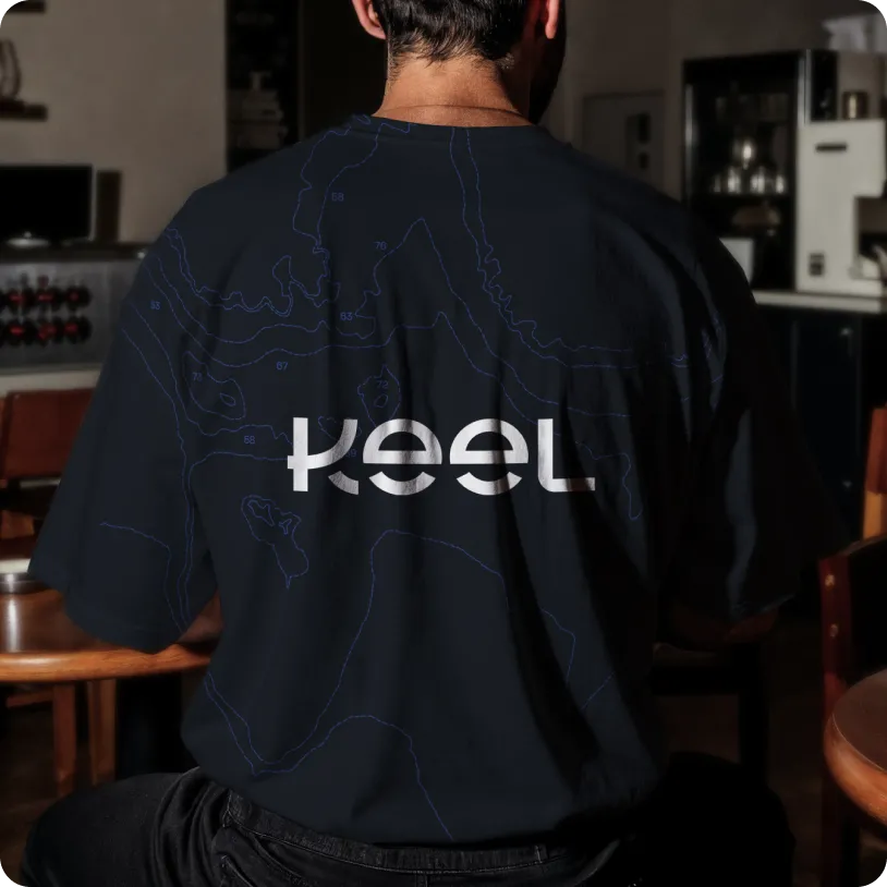 Back view of a person wearing a black T-shirt with a white stylized 'Keel' logo and faint blue contour lines.