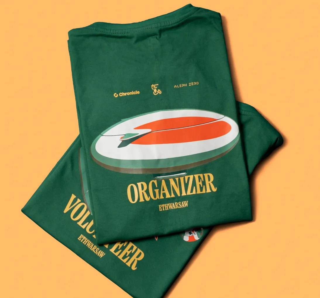 Two folded green T-shirts stacked, one labeled 'ORGANIZER ETHWARSAW' with logos and the other labeled 'VOLUNTEER ETHWARSAW'.