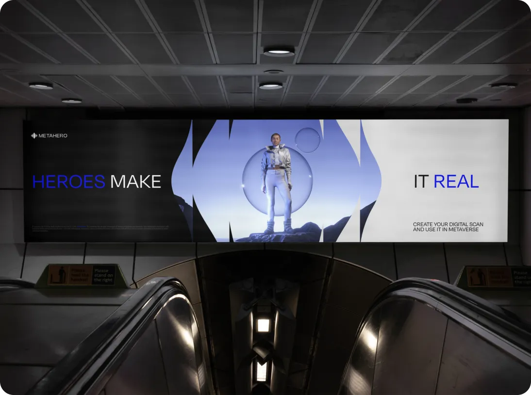 Billboard above escalators showing a futuristic astronaut figure with the text 'HEROES MAKE IT REAL' and an invitation to create a digital scan for the metaverse.