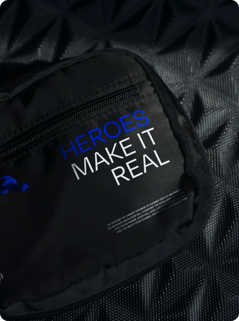 Black fabric surface with a zipper pocket featuring the text 'HEROES MAKE IT REAL' in blue and white letters.