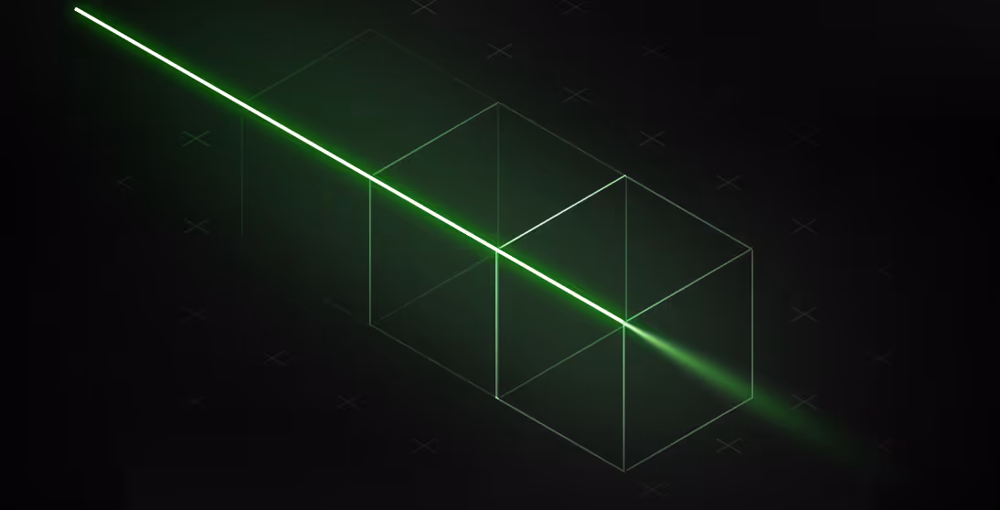 Green laser beam passing through two transparent wireframe cubes on a black background.