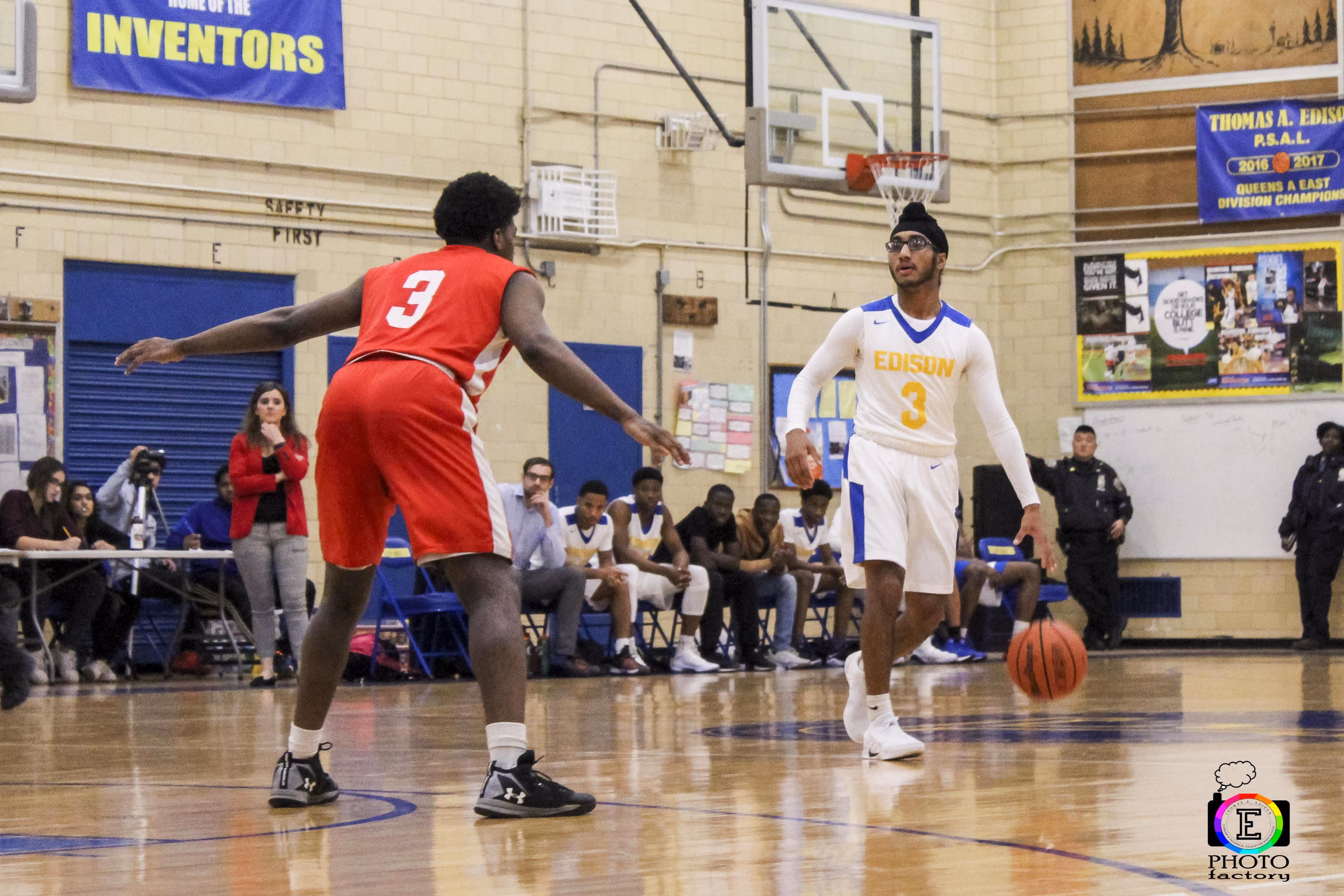 Edison number 3 dribbles ball against opponent during gym basketball game