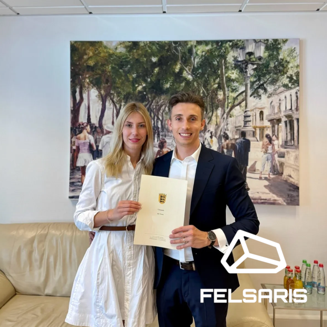 Zwei Personen stehen nebeneinander und halten gemeinsam eine Urkunde in die Kamera.