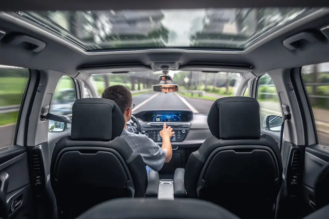 Driver in a car with road view and panoramic sunroof