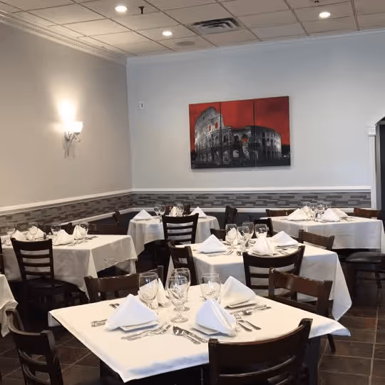 A restaurant with a painting of a building on the wall.
