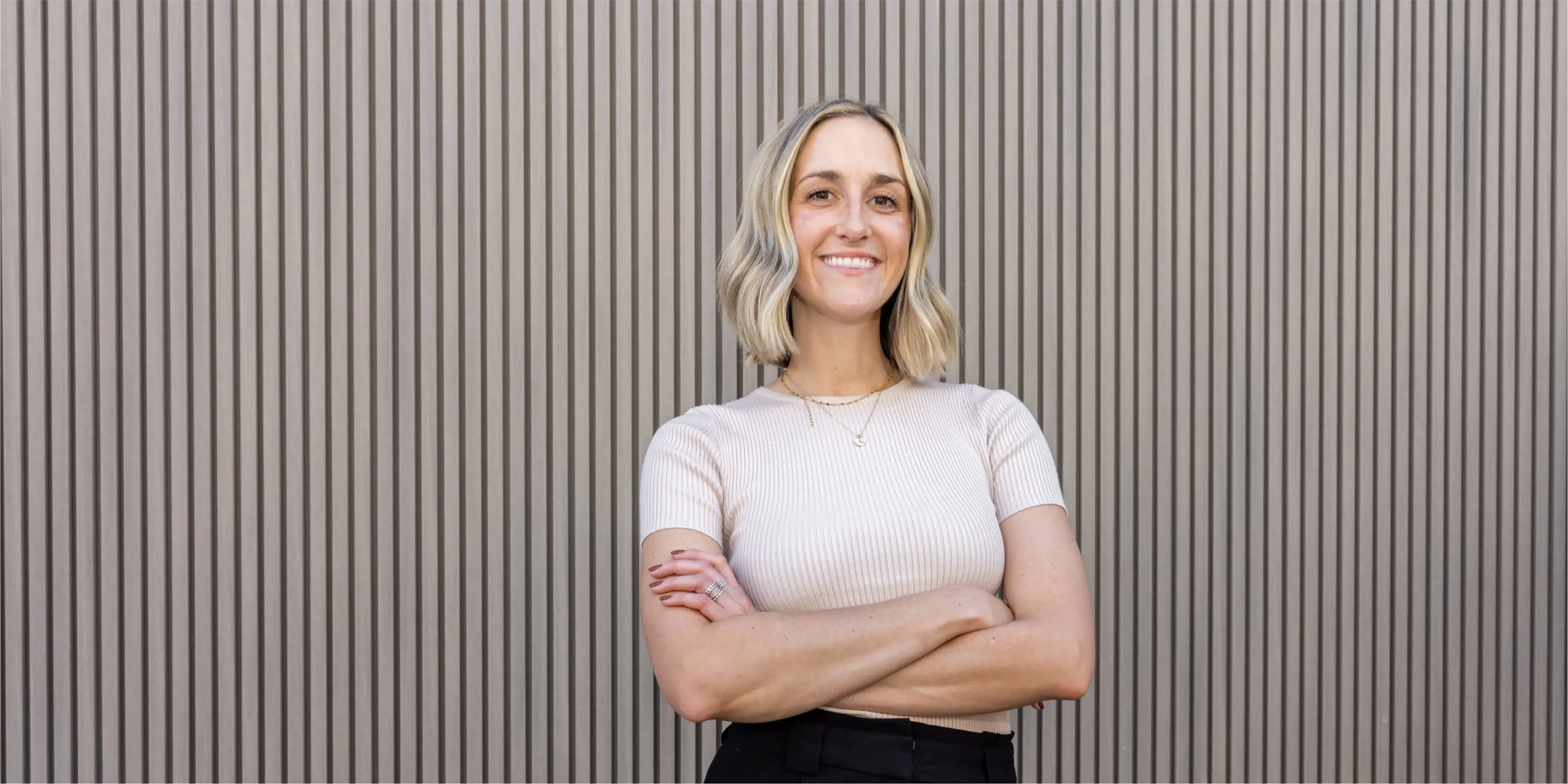 Dr. Toni Torres standing with her arms crossed in front of a wall.