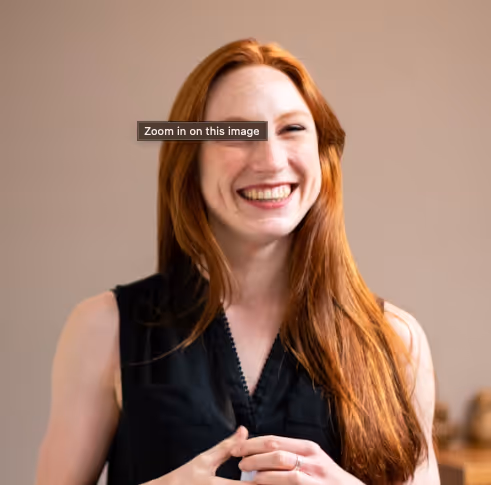 Customer testimonial photo of a smiling woman with red hair
