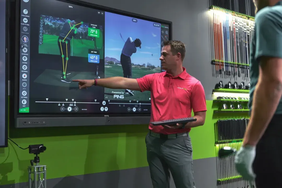 GOLFTEC coach pointing out OptiMotion explaining to student their swing mechanics 