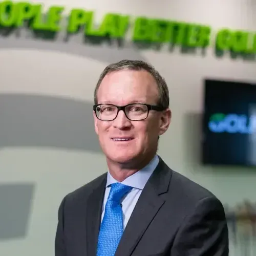 CEO Joe Assell headshot in GOLFTEC headquarters