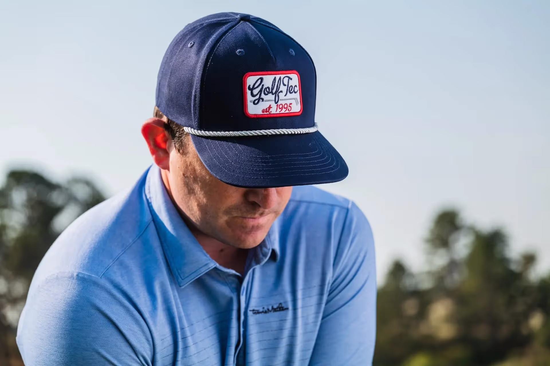 Man wearing GOLFTEC hat on the golf course