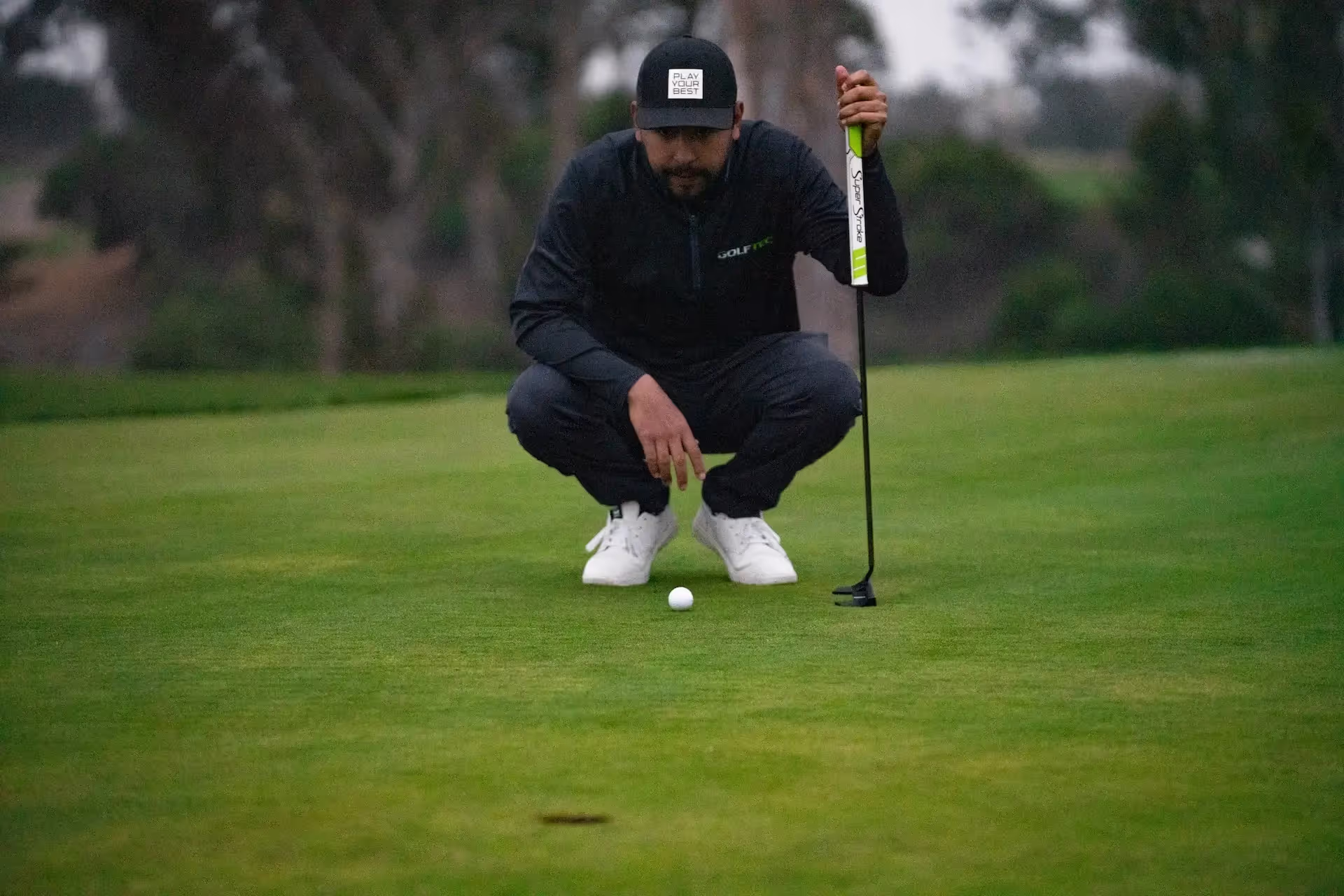 Golfer lining up his putt on green