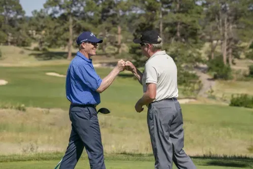 Two golfers fist bumping celebrating on the green 