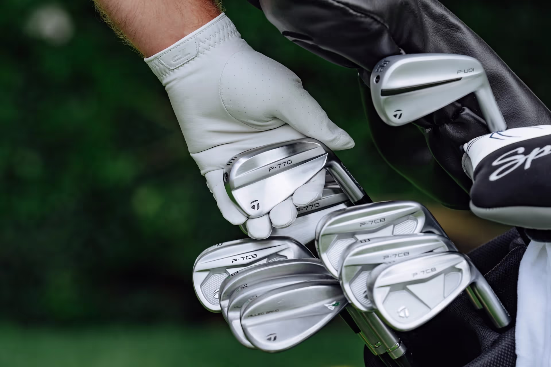 Golfer reaching for TaylorMade P770 iron from a golf bag on the course 