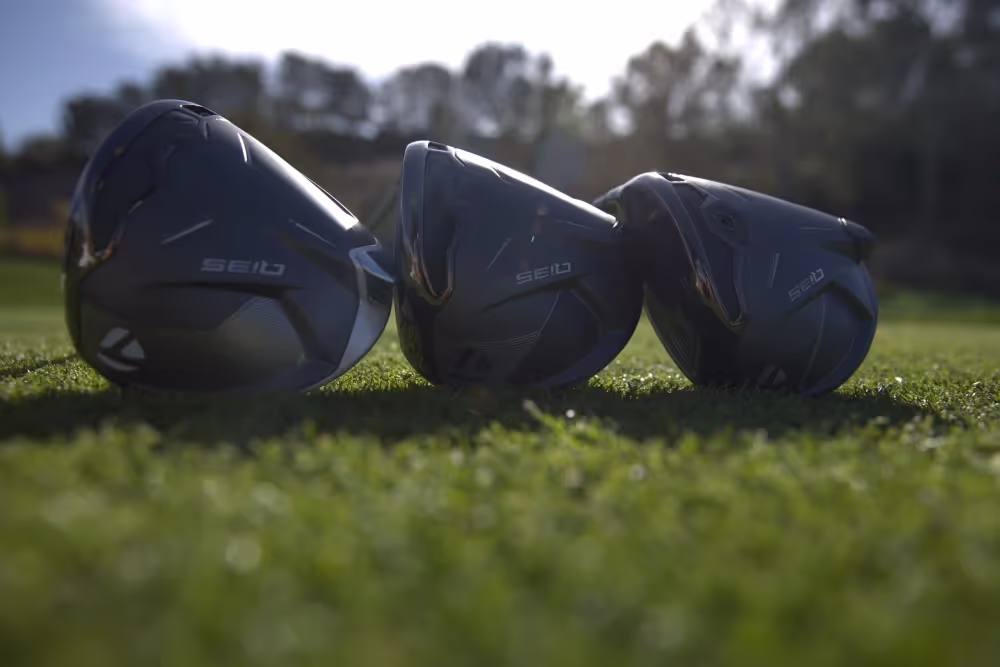 Three TaylorMade Qi35 Drivers on the green, arranged to showcase their design features 