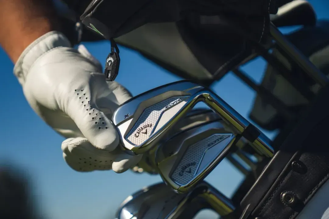 Golfer reaching for a Callaway iron in their golf bag. 